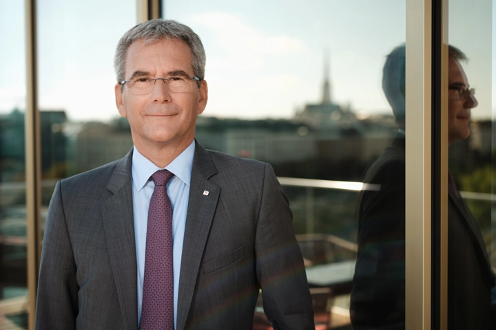 © Ian Ehm Vorstandsvorsitzender Hartwig Löger im Portrait, in der Spiegelung im Hintergrund Stephansdom unscharf