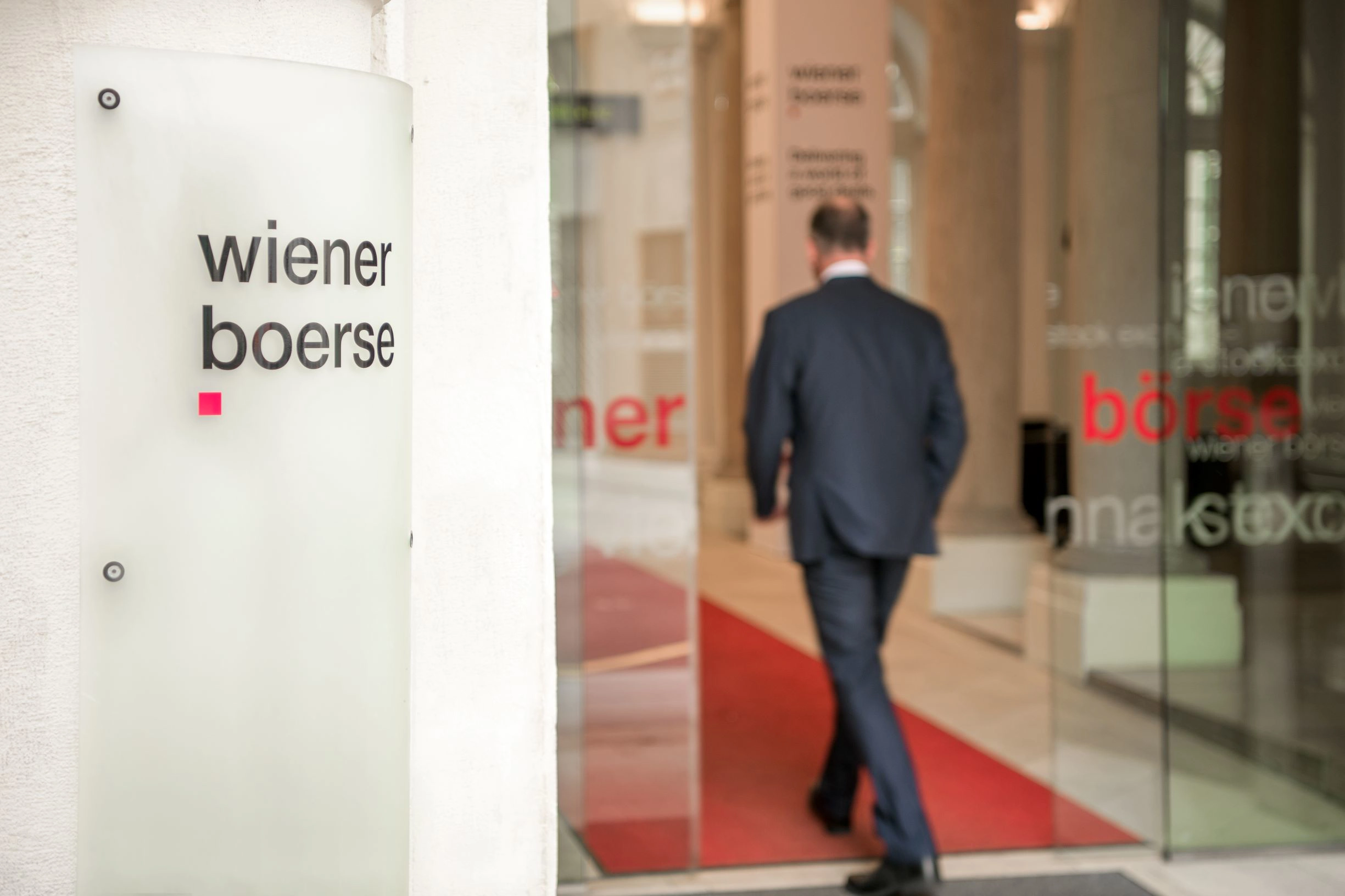 © Wiener Börse APA Fotoservice Mann tritt durch Glastüren in das Gebäude der Wiener Börse